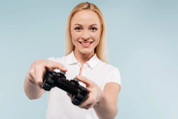 KYIV, UKRAINE - 25 NOVEMBRE 2020 : femme heureuse tenant un joystick sur fond flou isolé sur fond bleu — Photo de stock