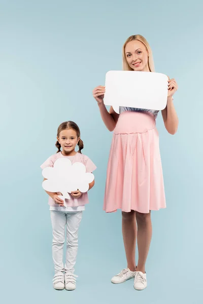 Pleine longueur de la mère enceinte et de l'enfant tenant la pensée et les bulles de parole sur le bleu — Photo de stock