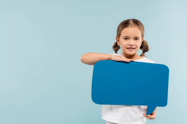 Criança feliz segurando bolha discurso isolado em azul — Fotografia de Stock