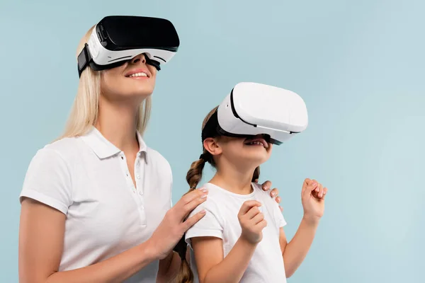 Fröhliche Mutter und glückliches Kind in vr Headsets isoliert auf blau — Stockfoto