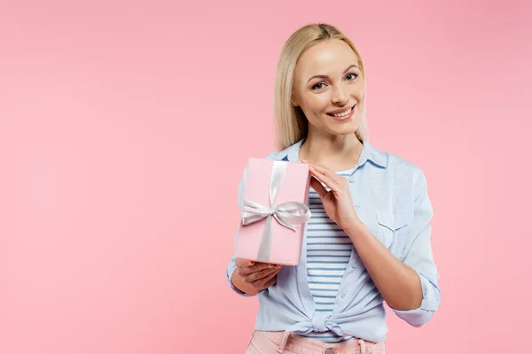 Femme heureuse tenant boîte cadeau enveloppé isolé sur rose — Photo de stock