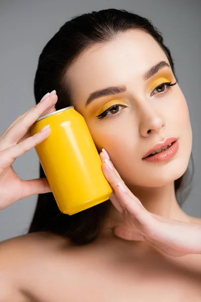 Brunette femme tenant boîte jaune avec boisson gazeuse isolé sur gris — Photo de stock
