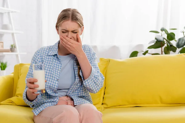 Женщина с аллергией чувствует отвращение, держа стакан молока — стоковое фото
