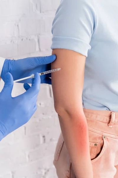 Vue recadrée du médecin faisant l'injection à une femme allergique en clinique — Photo de stock