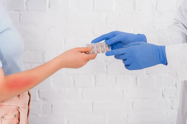 Vue recadrée du médecin donnant des pilules à une femme allergique — Photo de stock