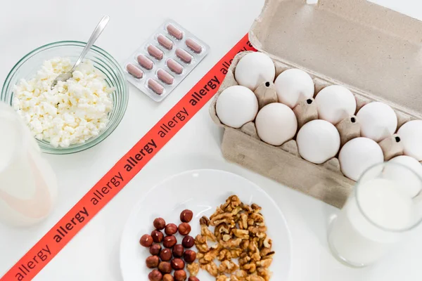 Ribbon with allergy lettering near milk, food and pills — Stock Photo