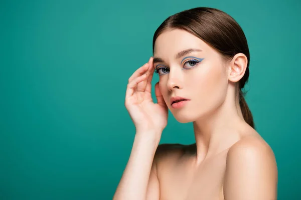 Charming woman looking at camera while touching face isolated on green — Stock Photo