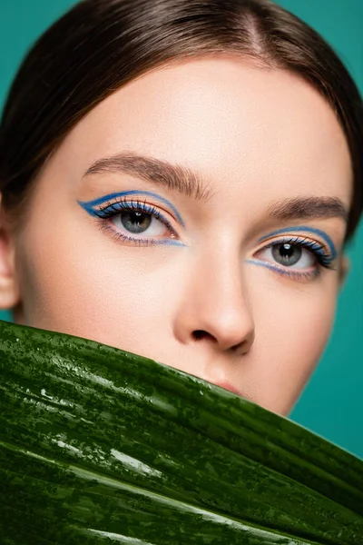 Close up portrait of young woman with creative visage posing near shiny leaf isolated on green — Stock Photo