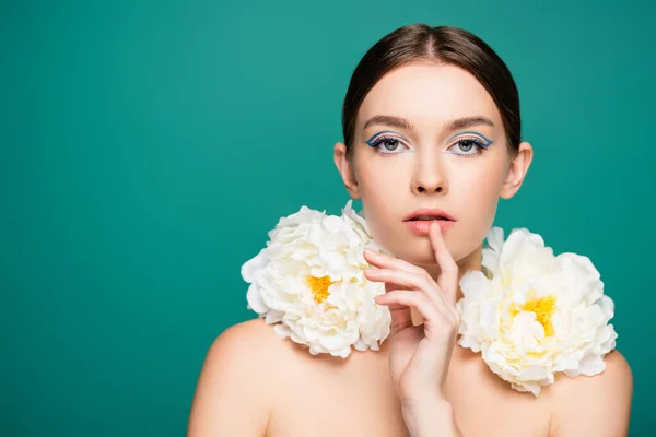 Charming woman with white peonies on shoulders looking at camera isolated on green — Stock Photo