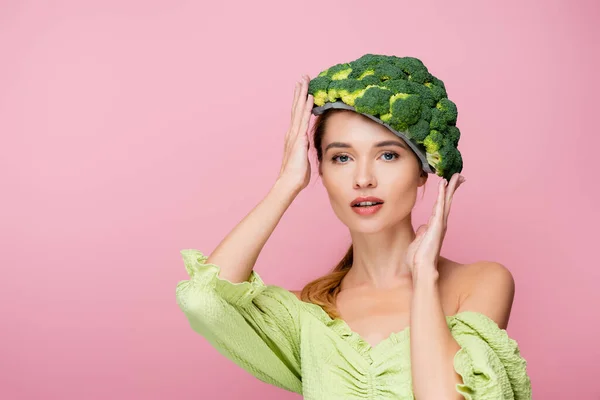 Jolie chapeau femme touchante en brocoli frais isolé sur rose, concept surréaliste — Photo de stock