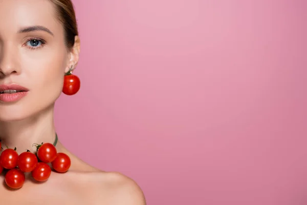 Vista recortada de la mujer en alegre collar de tomates mirando a la cámara aislada en rosa - foto de stock