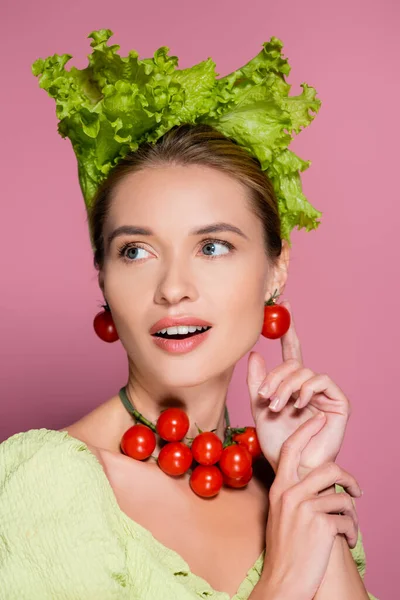 Jolie femme en chapeau de laitue, et boucles d'oreilles en tomates cerises sur rose — Photo de stock