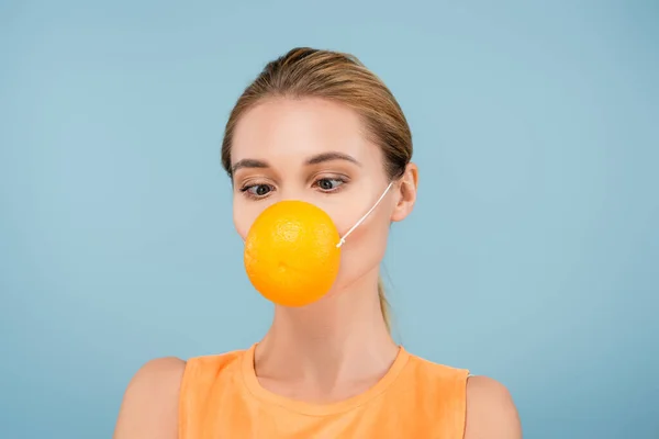 Jeune femme en masque de sécurité en orange à moitié isolé sur bleu — Photo de stock