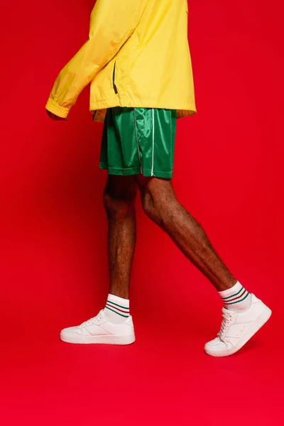 Cropped view of stylish african american man walking on red — Stock Photo