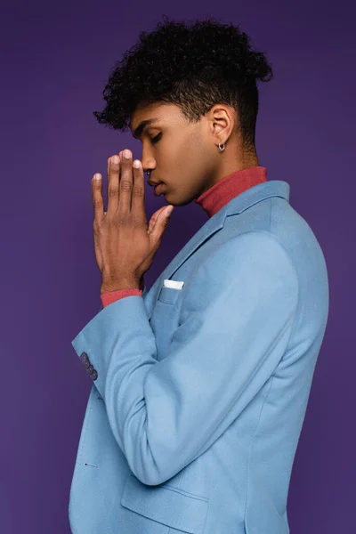 Side view of young african american man with closed eyes in stylish blazer on purple — Stock Photo