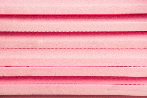 Hintergrund aus gestapeltem, rosa expandiertem Kunststoff — Stockfoto