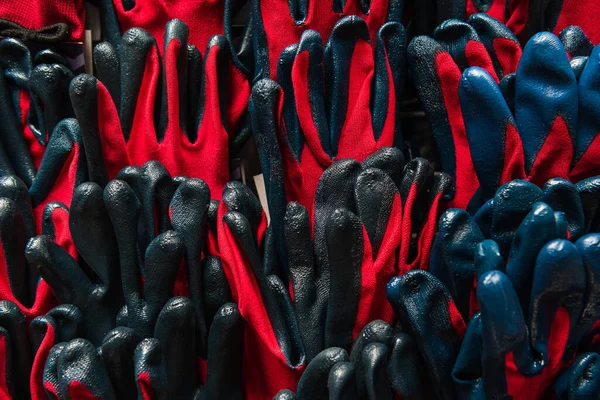 Fondo de rojo y negro, guantes de trabajo de goma idénticos, vista superior - foto de stock