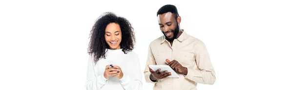 Glücklich afrikanisch-amerikanisches Paar mit Gadgets isoliert auf weiß, Banner — Stockfoto