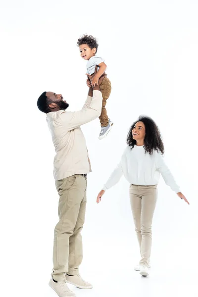 Eccitato africano americano uomo tenendo figlio vicino felice moglie su bianco — Foto stock