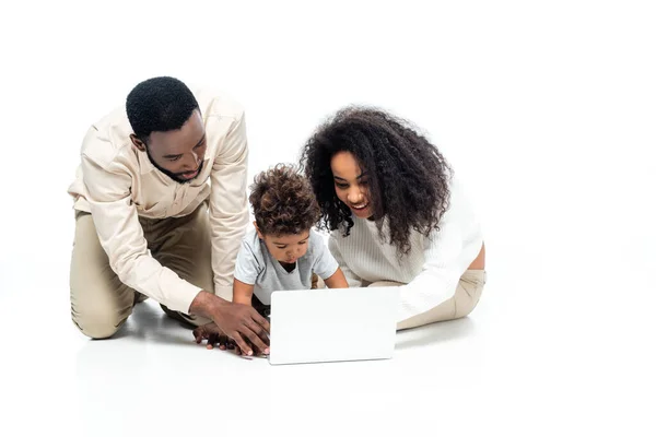 Couple afro-américain à l'aide d'un ordinateur portable avec tout-petit fils sur blanc — Photo de stock