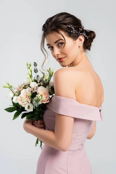 Charming bride with wedding bouquet looking at camera isolated on grey — Stock Photo