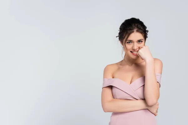 Flirty bride holding hand near face while looking at camera isolated on grey — Stock Photo