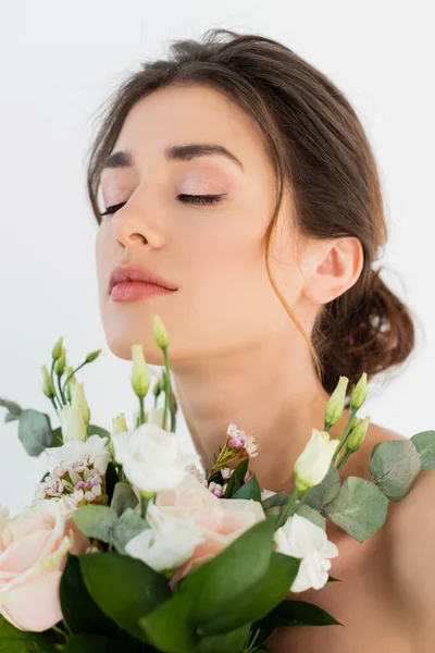 Jeune femme avec bouquet de mariage posant les yeux fermés isolé sur blanc — Photo de stock