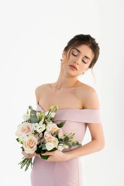 Sensual woman in dress, with naked shoulders, holding wedding bouquet isolated on white — Stock Photo