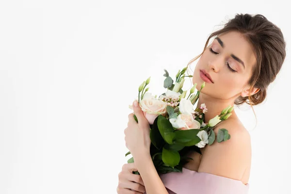 Jeune fiancée tenant bouquet de mariage tout en posant les yeux fermés isolé sur blanc — Photo de stock