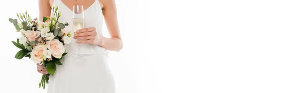 Partial view of fiancee holding champagne glass and wedding bouquet isolated on white, banner — Stock Photo