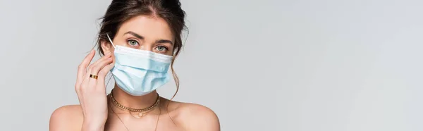 Joven novia en máscara médica mirando a la cámara aislada en gris, bandera — Stock Photo