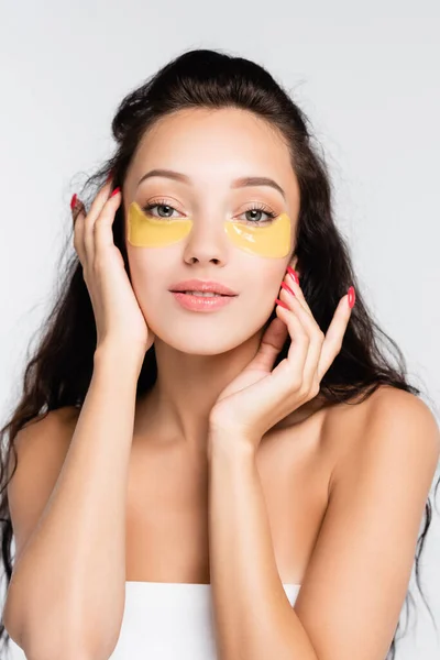 Brunette young woman with eye patches looking at camera isolated on white — Stock Photo