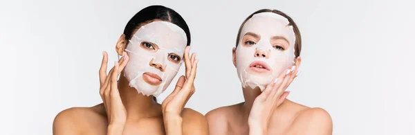 Mulheres multiétnicas jovens em máscaras de folhas hidratantes isoladas em branco, banner — Fotografia de Stock