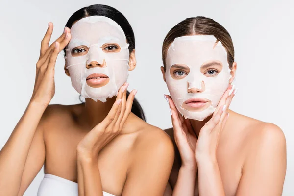 Mulheres multiétnicas jovens em máscaras de folhas hidratantes isoladas em branco — Fotografia de Stock