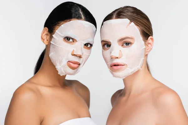 Mulheres multiétnicas em máscaras de folhas hidratantes isoladas em branco — Fotografia de Stock