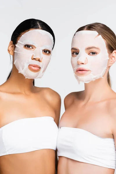 Mulheres jovens inter-raciais em máscaras de folhas hidratantes isoladas em branco — Fotografia de Stock