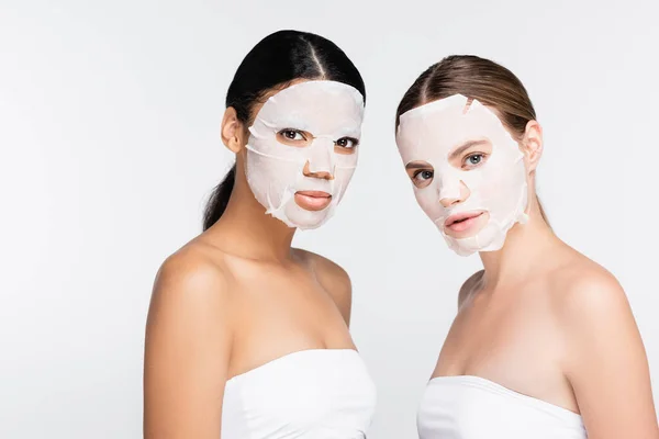 Mulheres inter-raciais em máscaras isoladas em branco — Fotografia de Stock