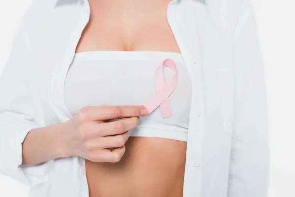 Vista ritagliata del nastro di consapevolezza del cancro al seno sul reggiseno della donna isolata su bianco — Foto stock