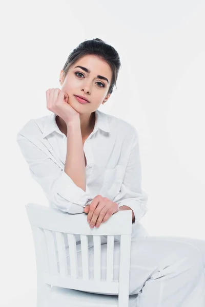 Giovane donna bruna seduta sulla sedia isolata sul bianco — Foto stock