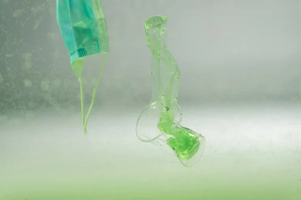 Medical mask, plastic bag and cup underwater, ecology concept — Stock Photo