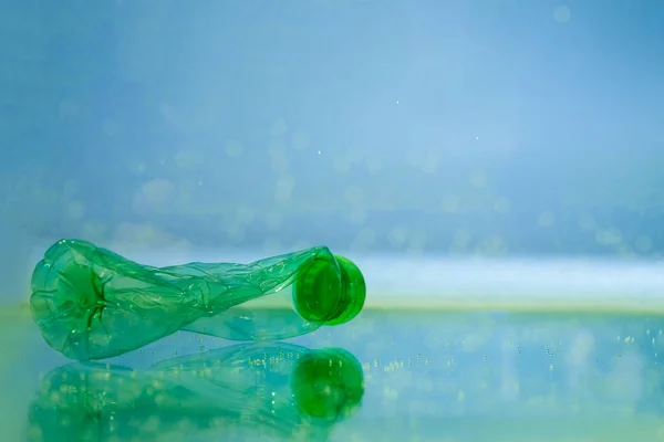 Botella de plástico arrugado en agua, concepto de ecología - foto de stock