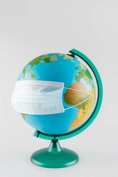 Protective mask on earth globe isolated on grey, ecology concept — Stock Photo