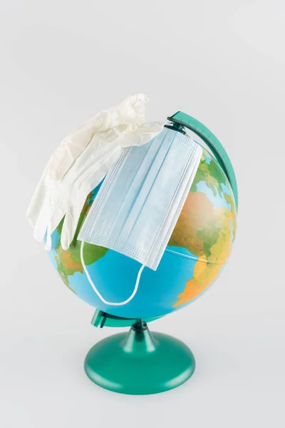Medizinische Maske und Latexhandschuhe auf Globus isoliert auf grau, ökologisches Konzept — Stockfoto