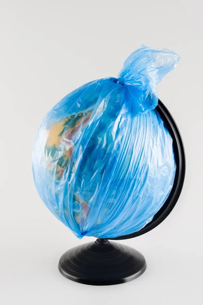 Globe emballé dans un sac en plastique isolé sur gris, concept écologie — Photo de stock