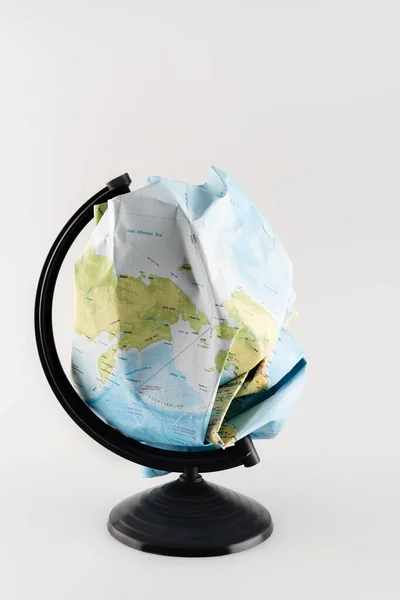 Crumpled map instead of globe on stand isolated on grey, ecology concept — Stock Photo