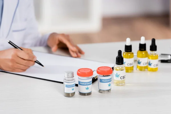 Partial view of african american doctor writing prescription on clipboard — Stock Photo