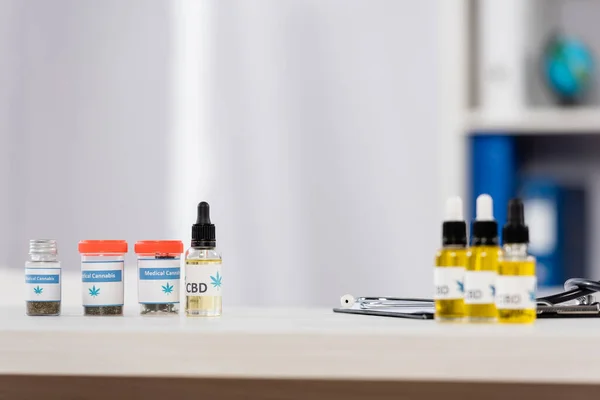 Bottles with medical cannabis and cbd lettering near clipboard on desk — Stock Photo