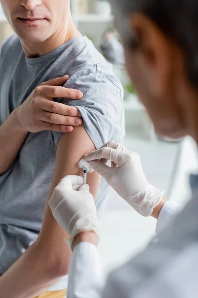 Лікар тримає шприц і бавовна під час вакцинації пацієнта — стокове фото
