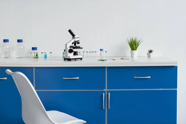 Microscope and vaccines on table in laboratory — Stock Photo