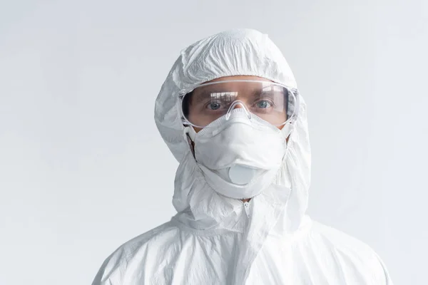 Вчений в захисній формі і масці дивиться на камеру ізольовано на сірому — стокове фото